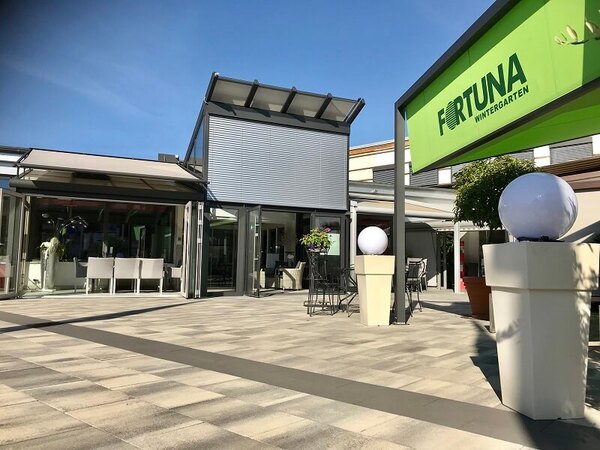 Moderner Wintergarten mit Glasfassade, Sonnenschutz und Terrasse bei Fortuna Wintergarten.
